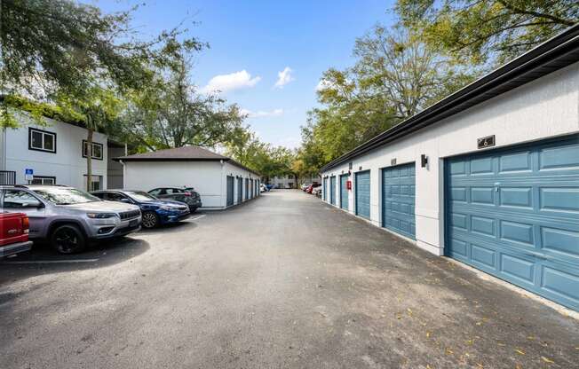 a city street with garages and parked cars