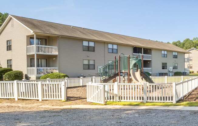 a view of an apartment building with a white fence