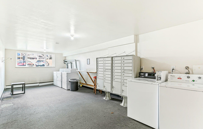 Bright and spacious laundry room featuring modern washers, dryers, and ample lockers for storage.
