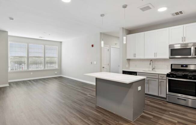a kitchen and living room with white walls and wood flooring at Metro 303, Hempstead, 11550