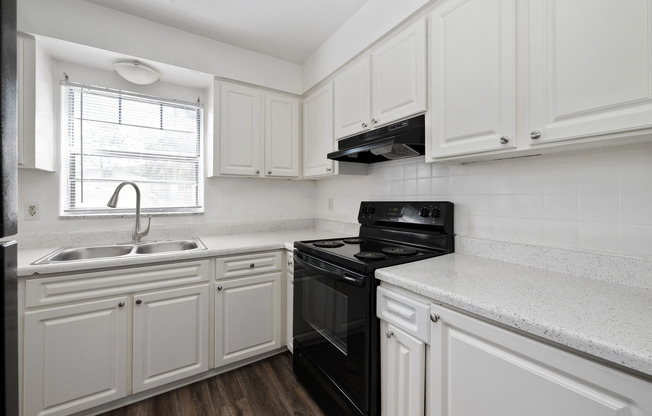 Bright and inviting kitchen with modern appliances, elegant white cabinetry, and a sleek countertop, perfect for culinary creativity.