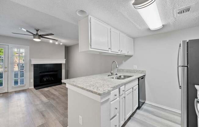 A kitchen with a white countertop and a black refrigerator.