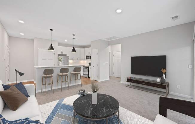 a living room with a couch and a coffee table and a kitchen