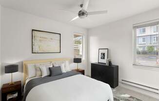 A bedroom with a bed, nightstand, and a painting on the wall.