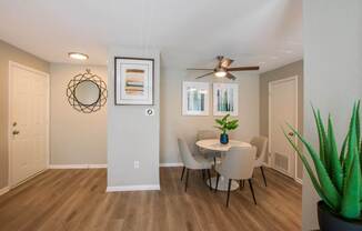 A dining room with a table and chairs.