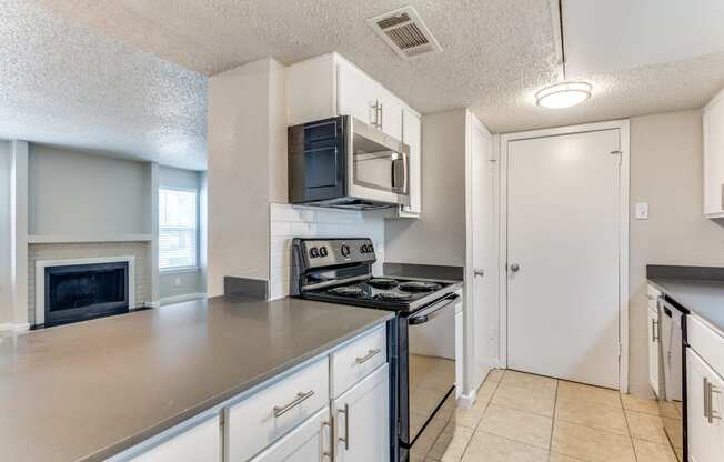 an empty kitchen with a stove and a microwave