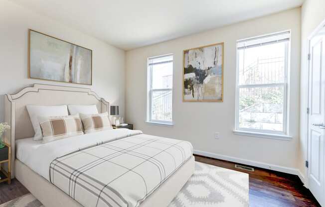 bedroom with bed, hardwood flooring and large windows at sheridan station south townhomes in washington dc