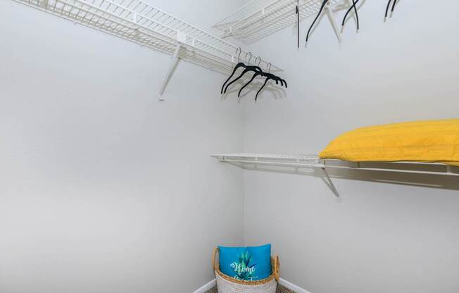 a closet with shelves and a yellow bed in it and a white wall with shelves at The Davis Apartments, Huntsville, AL  