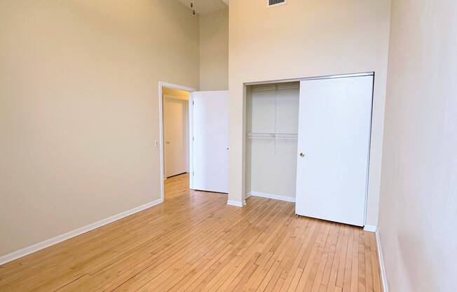 an empty living room with wood floors and a ceiling fan