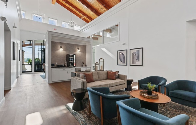 a living room with a vaulted ceiling and a kitchen in the background