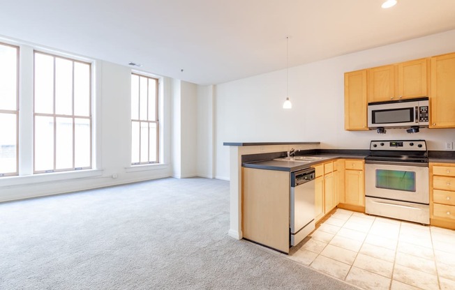 a kitchen with a stove top oven next to a window at 26 West, Managed by Buckingham Urban Living, Indianapolis