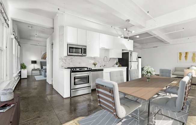 a kitchen and dining room with white cabinets and stainless steel appliances