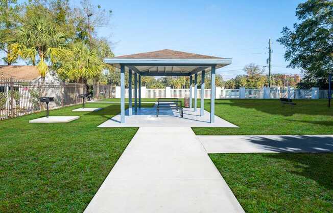 A pavilion with a white walkway in front of it.