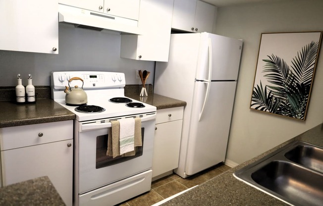 a kitchen with white appliances and a sink and a refrigerator