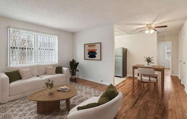 A living room with a white couch, a wooden coffee table, and a painting on the wall.