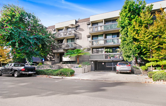 an apartment building with cars parked in front of it