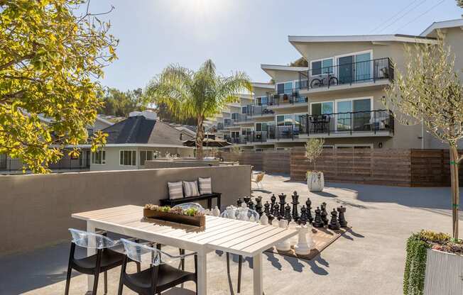 a patio with a table and chairs and a chess set