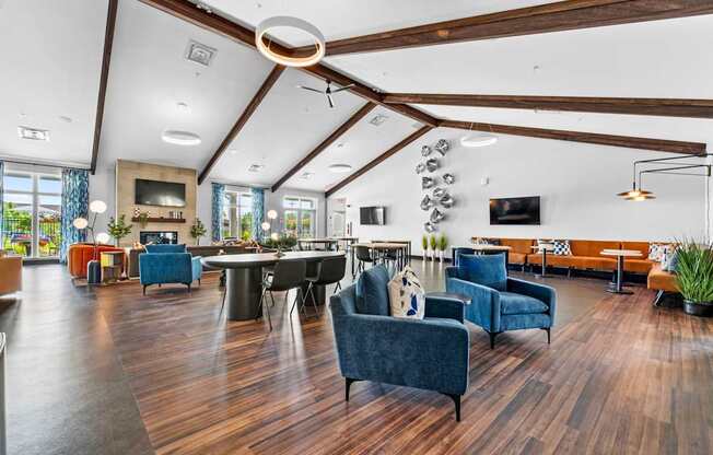 A spacious living room with a dark blue sofa and wooden floors.