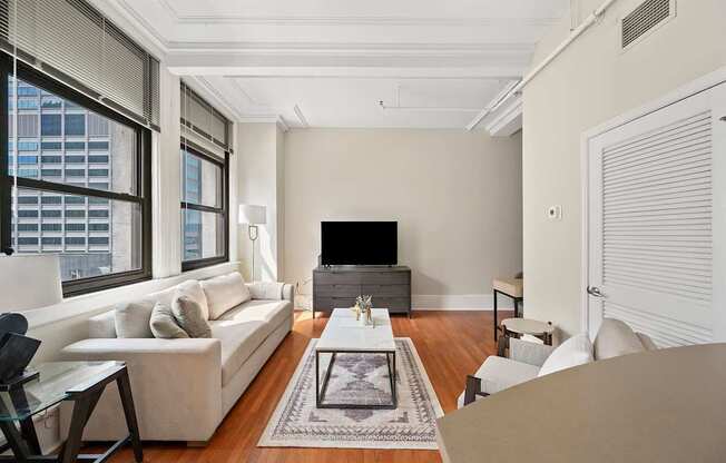 A living room with a white couch, a coffee table, and a flat screen TV.
