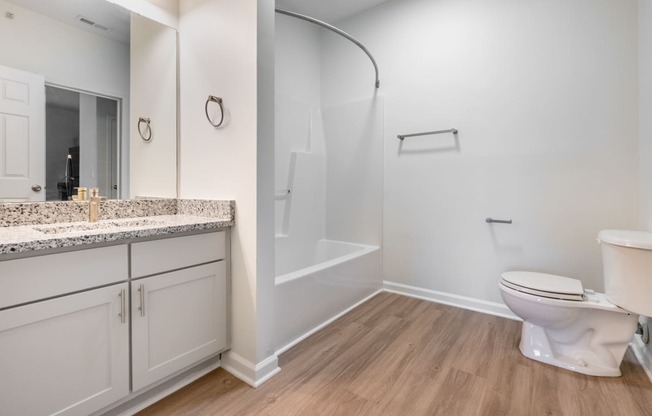 a bathroom with a toilet and a shower and a sink