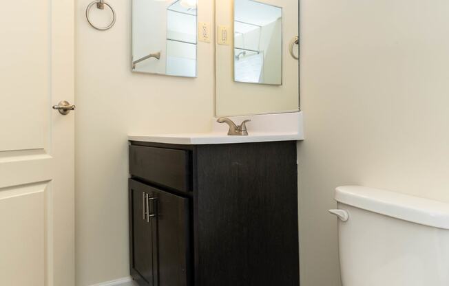 a bathroom with a toilet sink and mirror