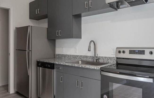 A modern kitchen with a stainless steel refrigerator, dishwasher, and oven.