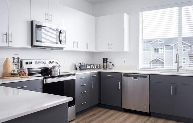 A modern kitchen with a white countertop and grey cabinets.