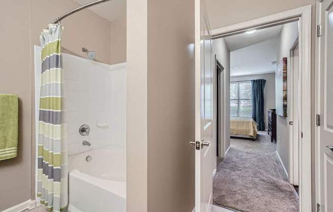 A bathroom with a shower curtain and a bathtub.