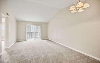 A room with a carpeted floor and a ceiling fan with five lights.