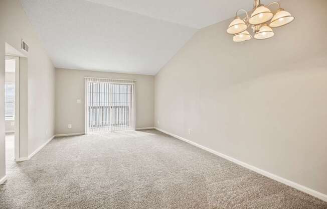 A room with a carpeted floor and a ceiling fan with five lights.