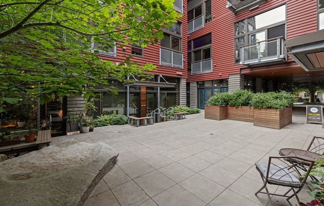 A courtyard with a table and chairs surrounded by buildings.
