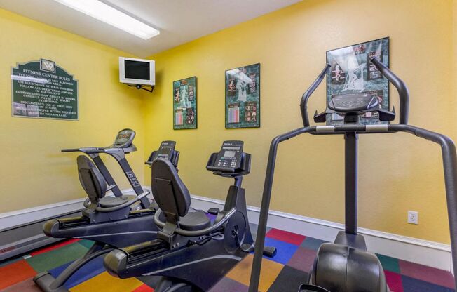 Fitness center with an elliptical and tv mounted in the corner