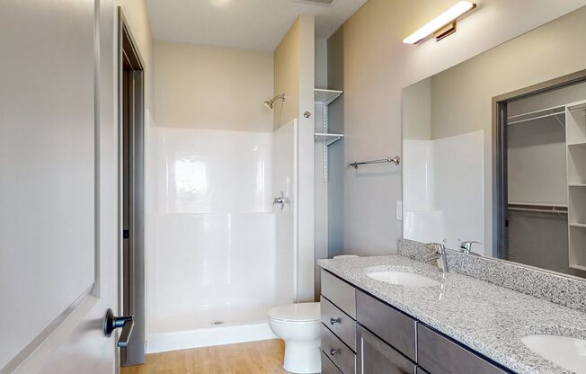 View of dual sink counter tops and shower in bathroom attached to the master bedroom at Haven at Uptown in Lincoln, NE