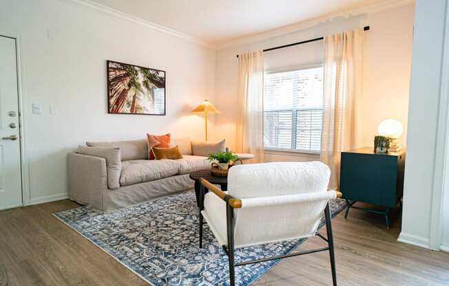 a living room with a couch and a chair and a window