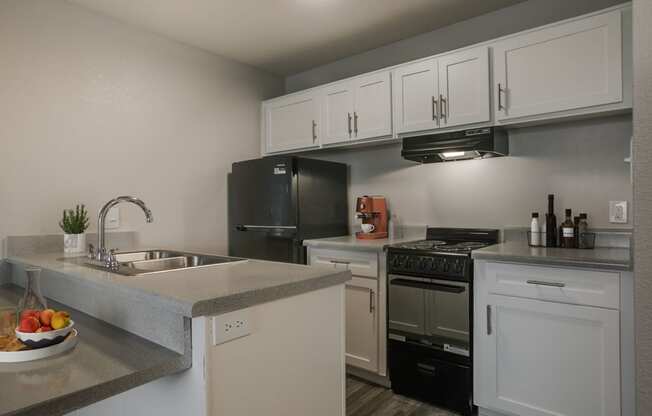 a kitchen with white cabinets and stainless steel appliances and a sink