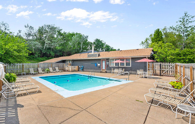 a pool with chairs around it and a building with a pool