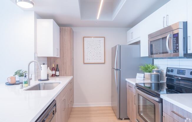 a kitchen with stainless steel appliances and white counter tops at Vue, San Pedro, CA 90731