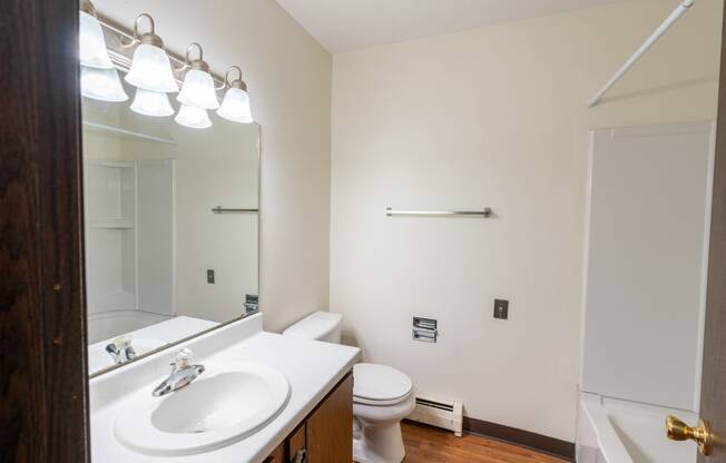 Bathroom with a white sink and toilet next to a white bathtub at Parkwest Gardens 58078 