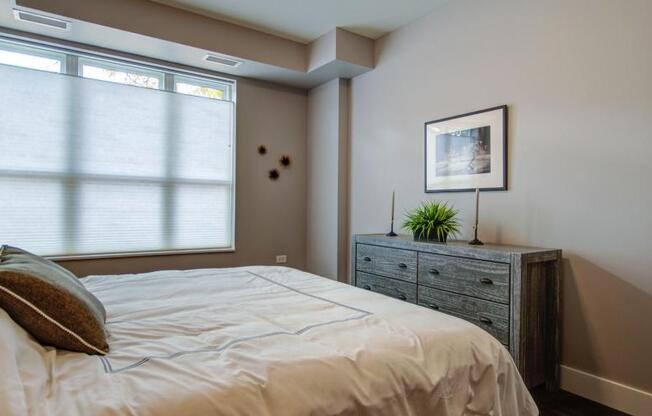 a bedroom with a bed and a dresser and a window at Barrington 101, Barrington Illinois