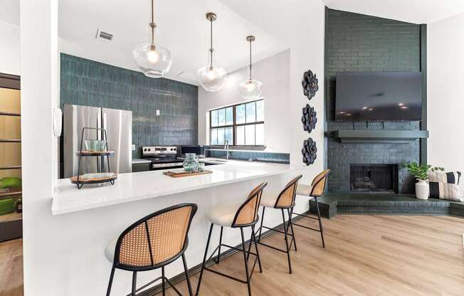 A kitchen with a bar area and a fireplace.