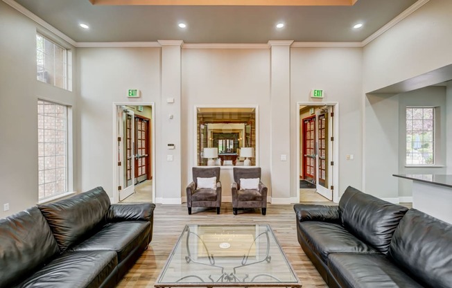 a living room with leather couches and a glass coffee table