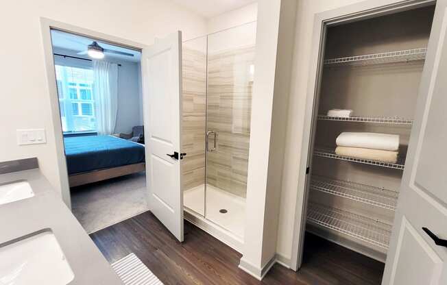 a small bathroom with a shower and a bed in a room