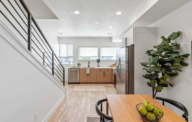 an open kitchen and dining room with a table and a bowl of fruit