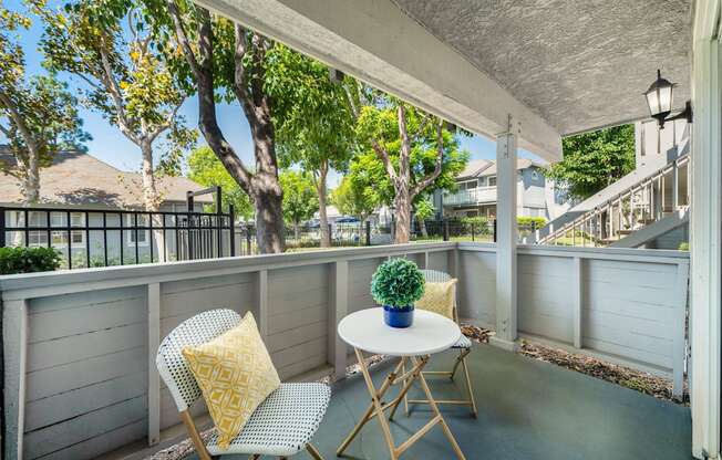 a patio with two chairs and a table on a balcony
