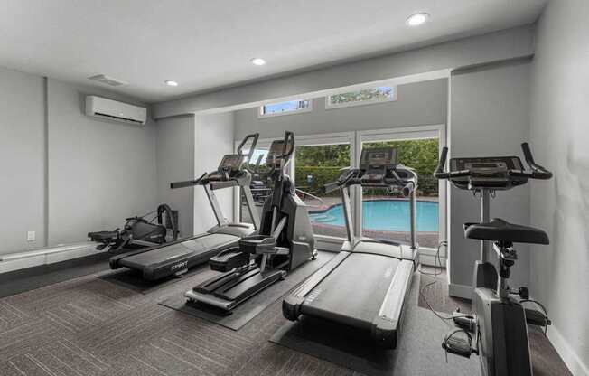 a gym with cardio equipment and a swimming pool