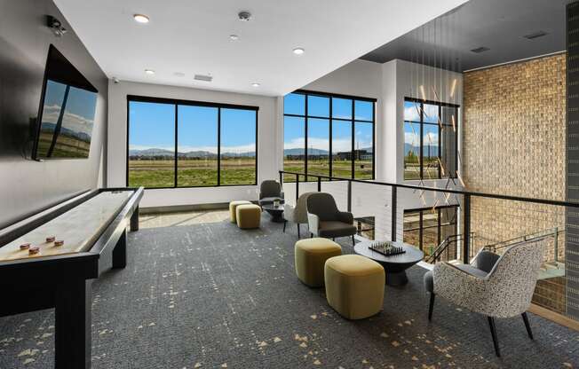 a living room with a view of a field and a table and chairs