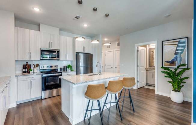 A kitchen with white cabinets and a wooden floor.