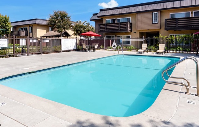 our resort style swimming pool is in front of our apartments with a fence