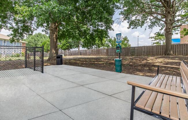 an empty park bench next to a fence