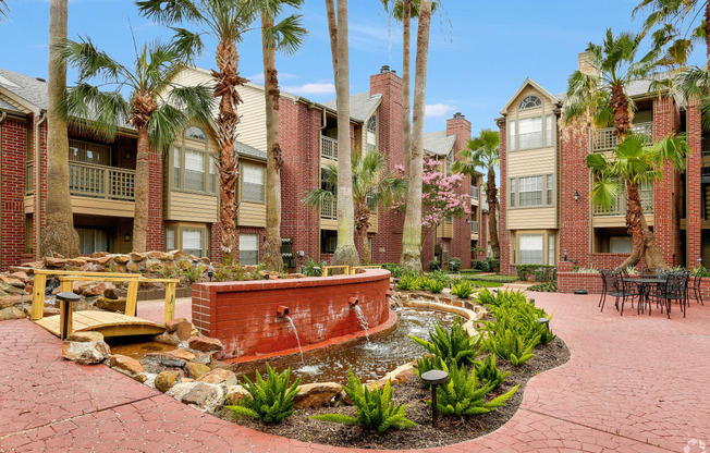 a courtyard with a fountain and palm trees